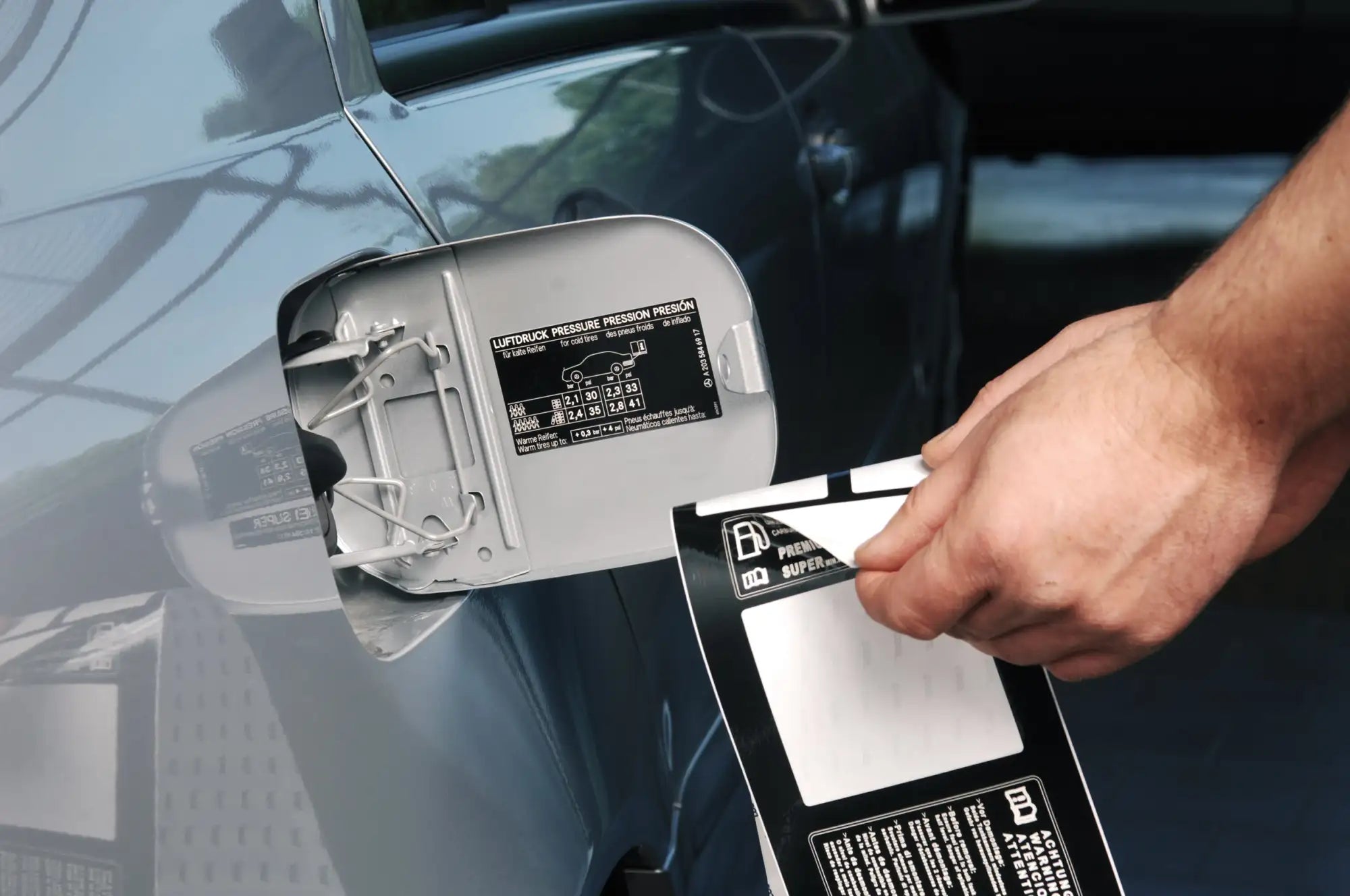 Silver metallic fuel cap with a sleek, modern design and embossed technical specifications label.