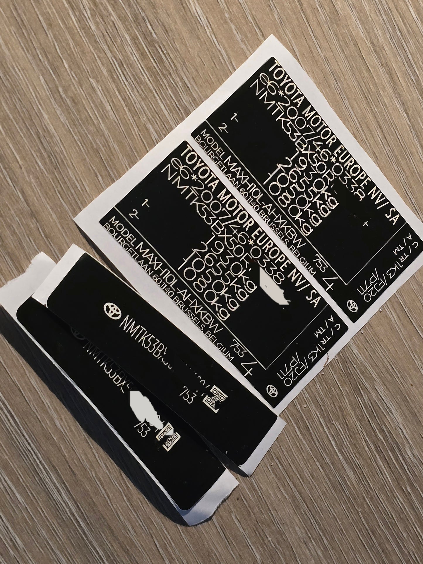 VINSHIELD UK vin stickers chassis plates vin tags data plates and anti tamper vin labels on wooden surface