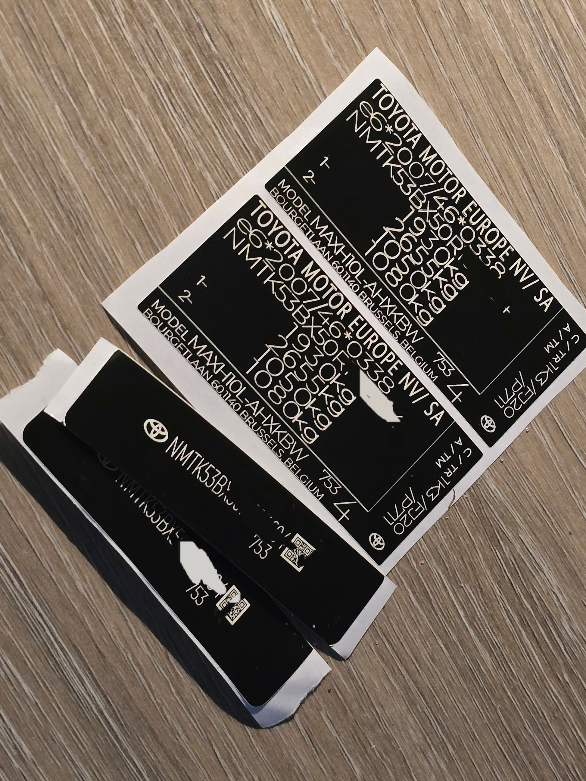 VINSHIELD UK vin stickers chassis plates vin tags data plates and anti tamper vin labels on wooden surface