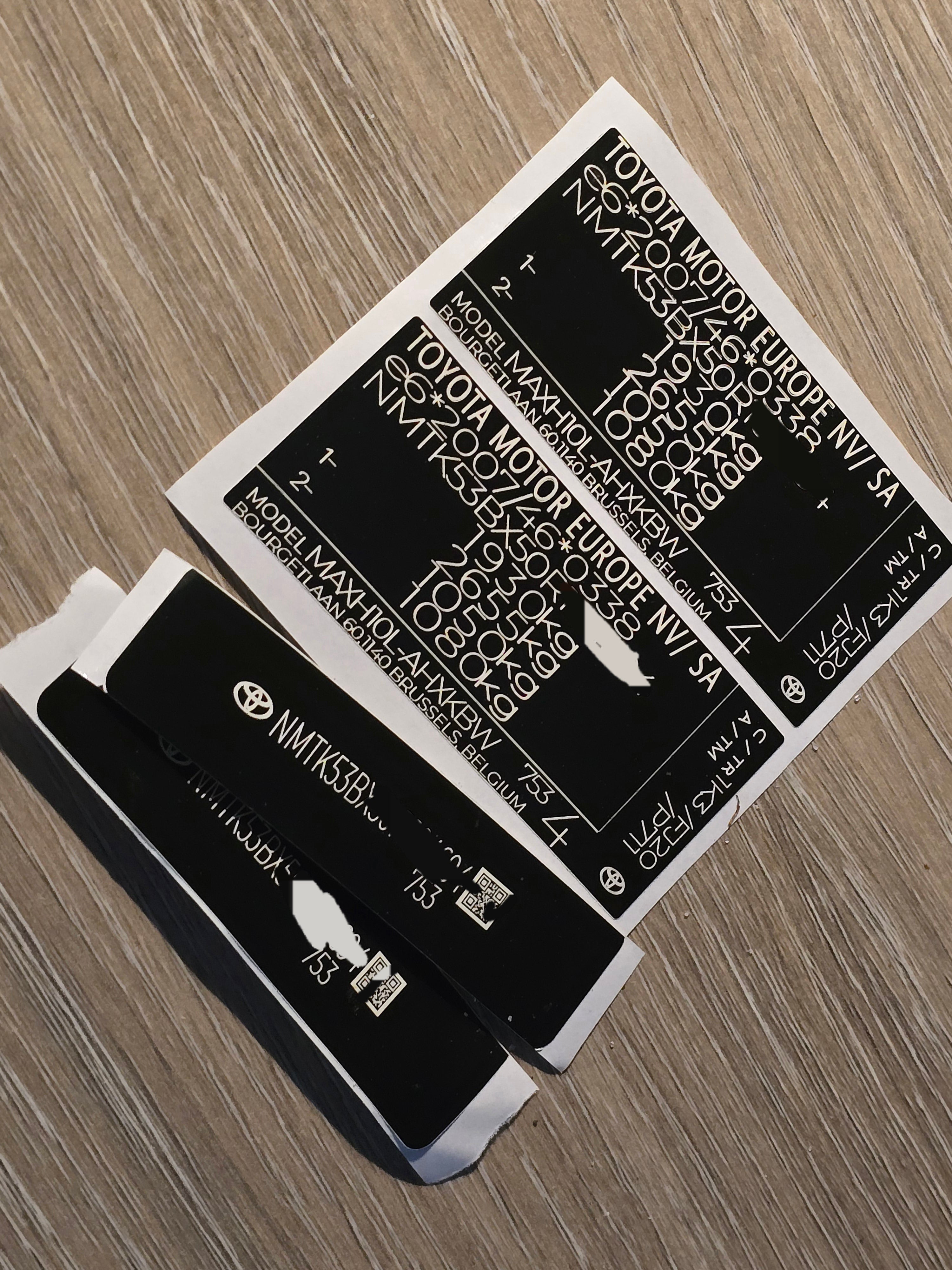 VINSHIELD UK vin stickers chassis plates vin tags data plates and anti tamper vin labels on wooden surface