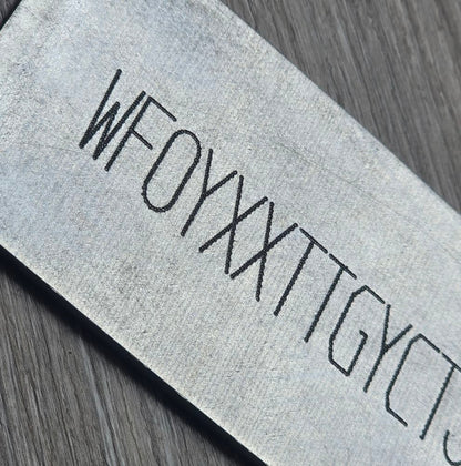 Close-up of a BMW replacement VIN sticker decal plate showing a serial number on textured surface