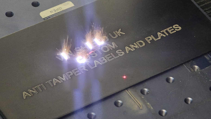 Close-up of VINSHIELD UK custom anti tamper labels and plates being engraved for BMW replacement VIN sticker
